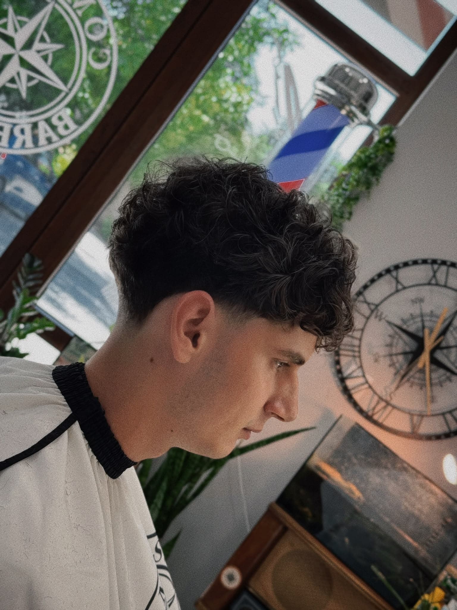 Curly fringe with a low fade – men's haircut in Haskovo